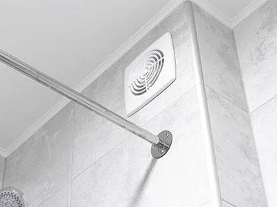 Bathroom fan installed above a tiled shower.